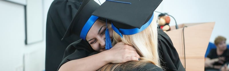 two women hugging after graduation, which can be reimbursed with expense software