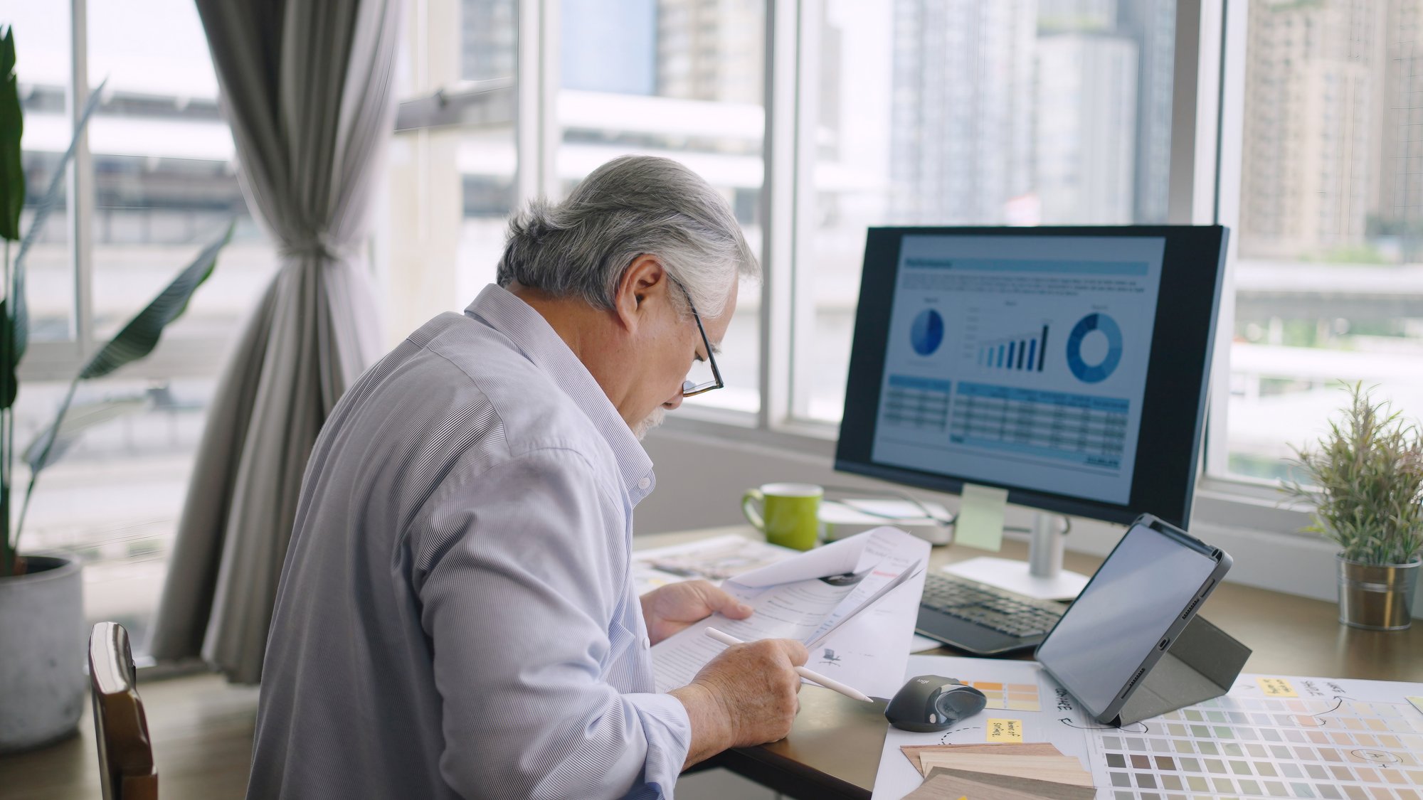 Finance leader comparing printed account codes against a reporting dashboard while mapping GP data to Business Central 